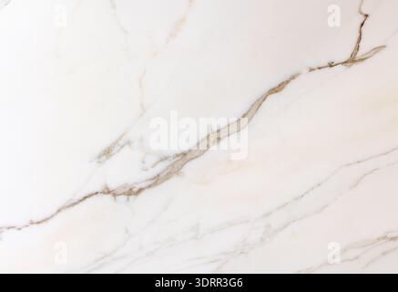 The image shows a close-up of a white marble surface with natural beige and gray veining. The organic lines create an elegant and minimal pattern, hig Stock Photo