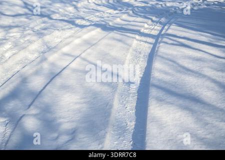 Snow-covered road with tire tracks, difficult driving conditions before the snow removal service arrives, concept for transport and traffic in the win Stock Photo