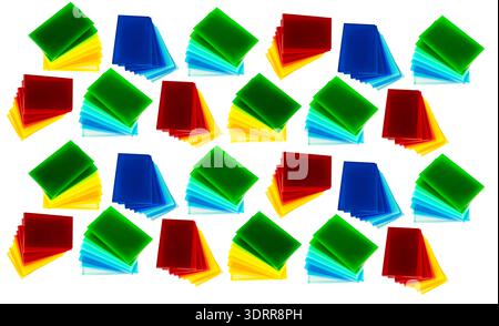Scattered colored acrylic sheets form abstract pattern, Translucent plastic squares in bright red blue green yellow orange and black overlap on white Stock Photo