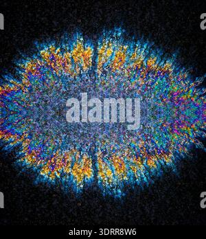 a photograph of an oil or petrol stain on a wet asphalt or pavement surface, a phenomenon called iridescence. interference of light waves reflecting o Stock Photo