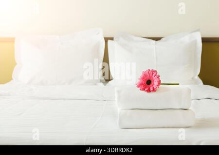 Collage of Towels and Flower on Bed in a Simple Room Setting During Daytime Stock Photo