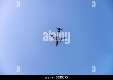 Airplane is flying on isolated blue sky Stock Photo