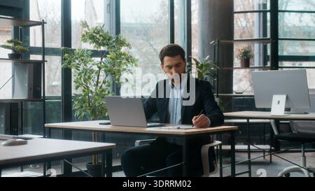Caucasian businessman typing laptop in office writing notes professional manager business man male leader boss working online executive guy browsing Stock Photo