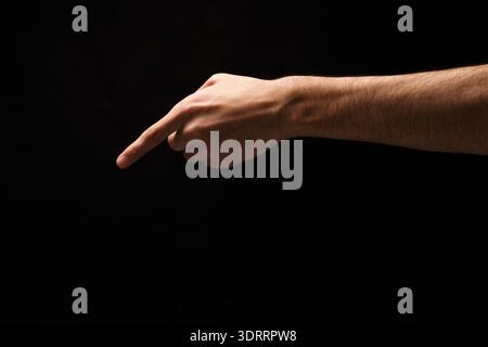 Hand Gesture Pointing in Dark Background Setting as Part of a Collage Creation Stock Photo