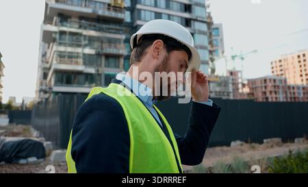 Pensive dissatisfied Caucasian man inspecting controlling building city engineer thoughtful sad shocked confused worker in hardhat check industry Stock Photo
