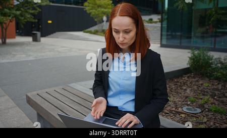 Caucasian businesswoman consulting client use laptop video call outdoor talking employer hr manager freelancer girl business woman conference distant Stock Photo