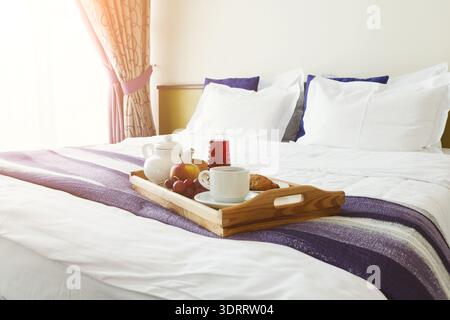 Fresh Breakfast Served on a Wooden Tray in a Cozy Hotel Room Setting Stock Photo