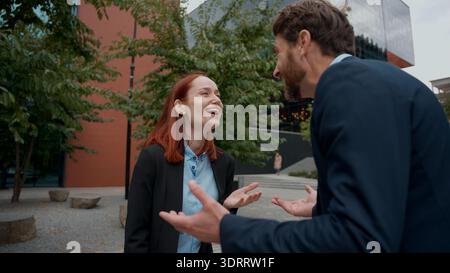 Caucasian happy business partners woman man laughing talking colleagues in city work break office outside collaborate businessman talk businesswoman Stock Photo
