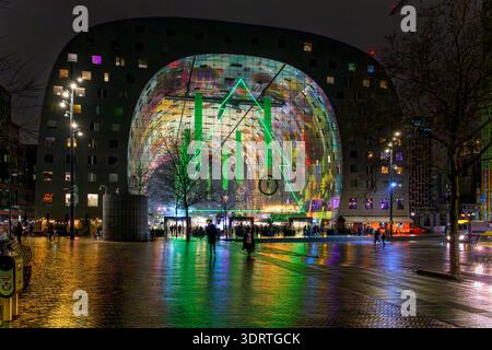 Reflections on the pavement outside the Market Hall (Markthal) in Rotterdam. Lit by the bright lights on the mural adorning the ceiling inside. Stock Photo
