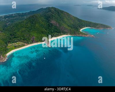Aerial view of lush green forests meeting the turquoise waters surrounding the sandy beaches of La Digue Island, Anse Reunion, La Digue, Seychelles. Stock Photo