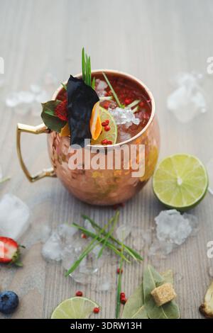 Cocktail With Fresh Ingredients in Copper Cup on Wooden Table With Ice Stock Photo