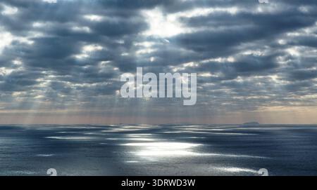 Sun rays breaking through dark clouds over the Mediterranean Sea. Stock Photo