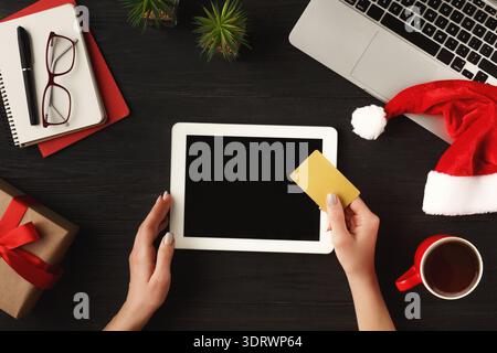 Collection of Holiday Items and Online Shopping on a Tablet in a Cozy Setting Stock Photo