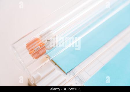 Close up of paper cutter with blue cardstock and measurement grid, scrapbooking and paper craft concept Stock Photo
