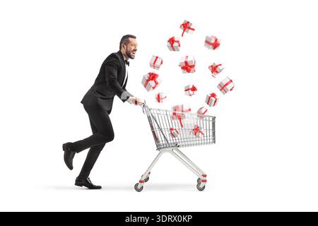 Man in a suit pushing a shopping cart with falling gift boxes isolated on white background Stock Photo