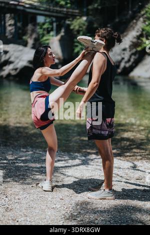 Friends practicing kickboxing outdoors by the river, summer fitness and balance training session Stock Photo