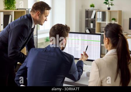 Business team analyzing data on computer, planning strategy and tasks in office Stock Photo