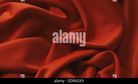 Smooth and elegant red synthetic fabric draped in soft flowing folds with a subtle matte texture. Close up. Stock Photo