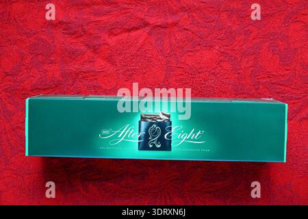 After eight candy box. Classic English mint chocolate. Red cloth as background. Stock Photo