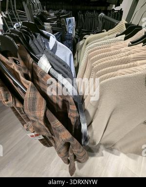 Pforzheim Germany Februar 19, 2026 Rack Of Plaid Shirts And Knit Sweaters, Closeup Texture And Warm Tones, Shopper Perspective On Layered Fall Collect Stock Photo