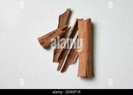 Whole cinnamon sticks arranged on a white surface. Close up showing texture, natural color, and detail of the spice, perfect for culinary, food Stock Photo