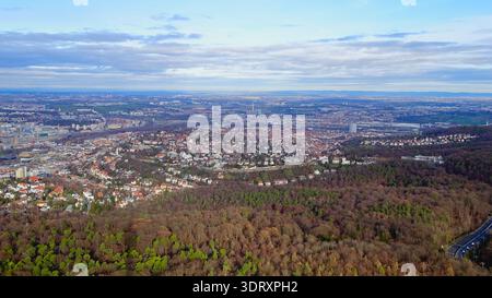 Open landscape combining urban areas and forested regions under a cloudy sky, highlighting the blend of nature and city. Stock Photo