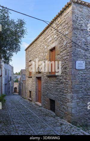 A detailed, high-angle close-up capturing the rustic texture of the traditional cobblestone pavement (balate) in the medieval streets of Erice, Sicily Stock Photo