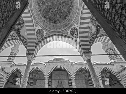 Close-up view of the intricate hand-painted ornaments, stone arches, and architectural details of the historic Uc Serefeli Mosque in Edirne, Turkey. Stock Photo