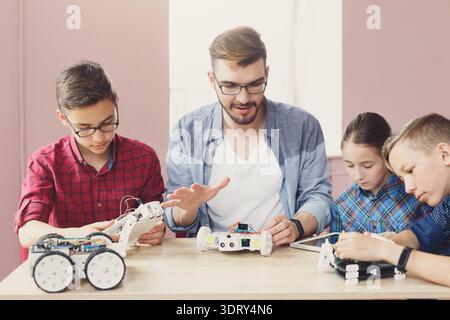 Group of Children Learning About Robotics and Programming in a Classroom Stock Photo