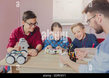 Kids Learn Robotics Skills During an Educational Activity With a Teacher in a Classroom Stock Photo