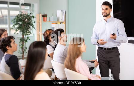 Male teacher explaining topic to students using digital board Stock Photo
