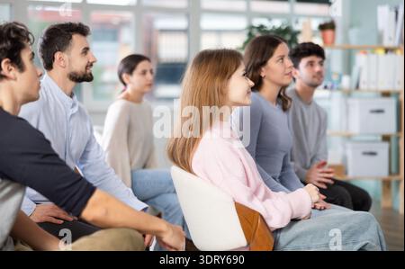 Group of young students listening during seminar in a modern classroom Stock Photo
