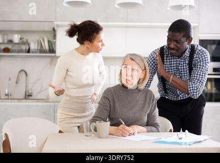Couple discussing testament with elderly woman Stock Photo