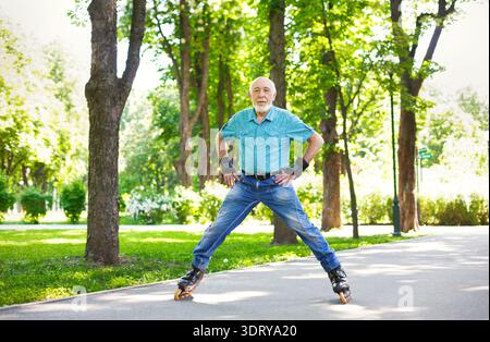 Senior Man Enjoys Inline Skating in a Park on a Sunny Day Stock Photo