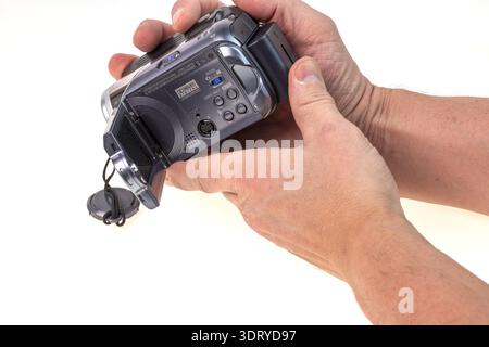 Close up view of hands holding vintage camcorder isolated on white background. Sweden. Stock Photo