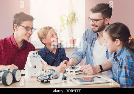 Kids Learn About Robotics With Guidance From an Instructor in a Classroom Setting Stock Photo