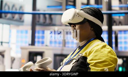 Photovoltaics smart factory specialist fixing damaged IoT sensors using VR tech. Mechanic in industry 4.0 solar panels plant using innovative virtual reality tech to find and fix errors, camera B Stock Photo