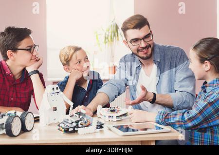 Kids Learn Robotics With Teacher in Classroom Setting During Afternoon Session Stock Photo