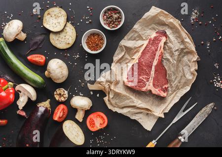 Collection of Fresh Vegetables and Raw Meat Laid out on a Black Surface for Meal Preparation Stock Photo