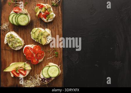 Mosaic of Colorful Vegetable Toppings on Bread Arranged on Wooden Board Stock Photo