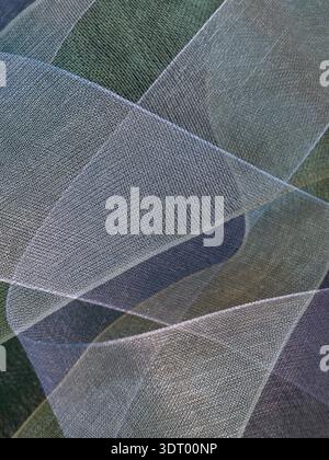 Fabric ribbon with new clean border of color blending wraps & swirls seen in artistic fashion for background showing light weight, fluffy, netting. Stock Photo