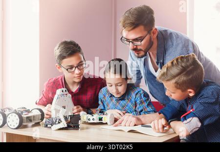 Students Learn Robotics With Guidance in Classroom During Technology Session Stock Photo