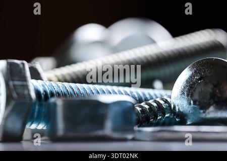 Macro view of various metallic fasteners including bolts and screws in a professional workshop Stock Photo