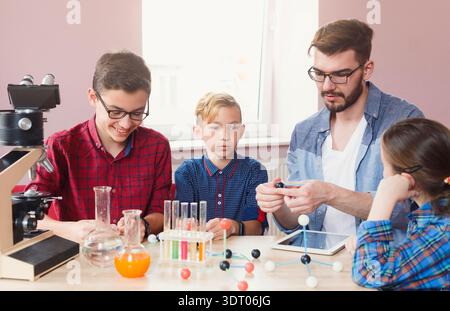 Kids Learning Science With Teacher During Hands-On Class in Classroom Setting Stock Photo