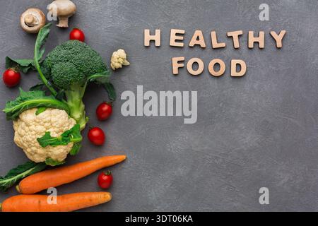 Fresh Vegetables and Letters Spell Healthy Food on a Gray Background Stock Photo