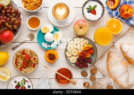 Celebration of Breakfast Items With Fruits, Pastries, and Drinks on a Wooden Table Layout Stock Photo