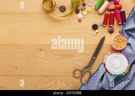 Crafting Session With Fabrics, Buttons, Scissors, and Threads on a Wooden Table Stock Photo