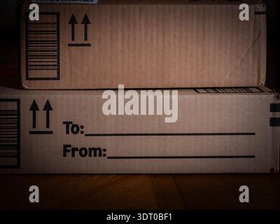 Stacked cardboard boxes with “To” and “From” labels printed on the front, symbolizing delivery, packaging, and logistics Stock Photo