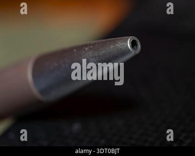 Macro close-up of a black pen tip against dark background, symbolizing writing, focus, and creativity in minimal composition Stock Photo