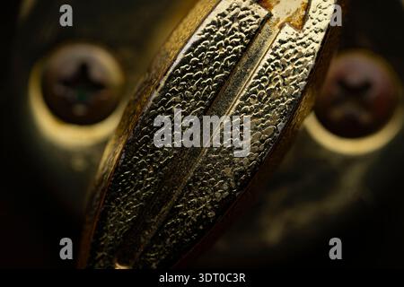 Extreme macro close-up of a textured metal screw head showing grooves and patina, symbolizing craftsmanship, age, and industrial design Stock Photo